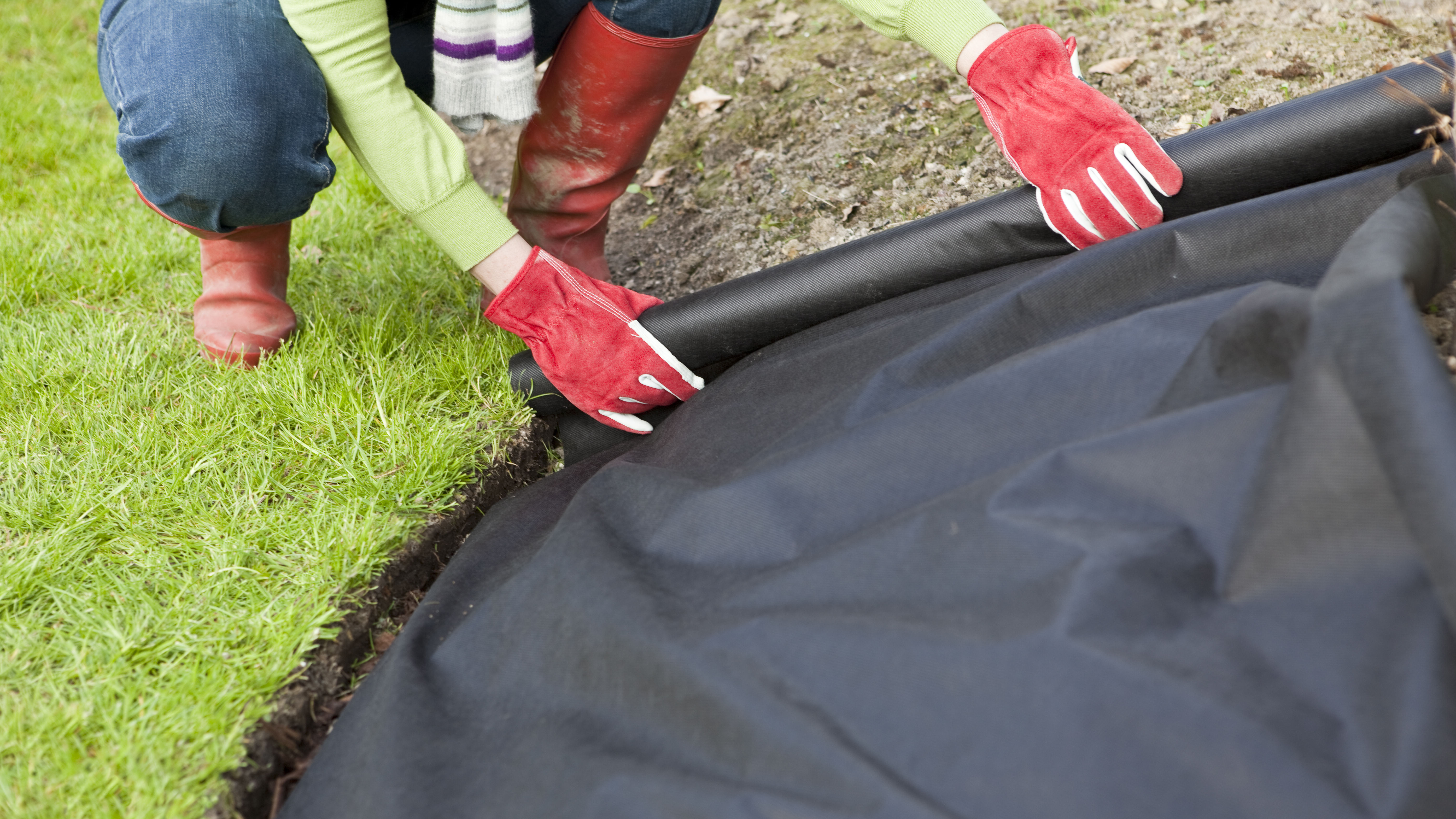 Woman laying a weed barrier