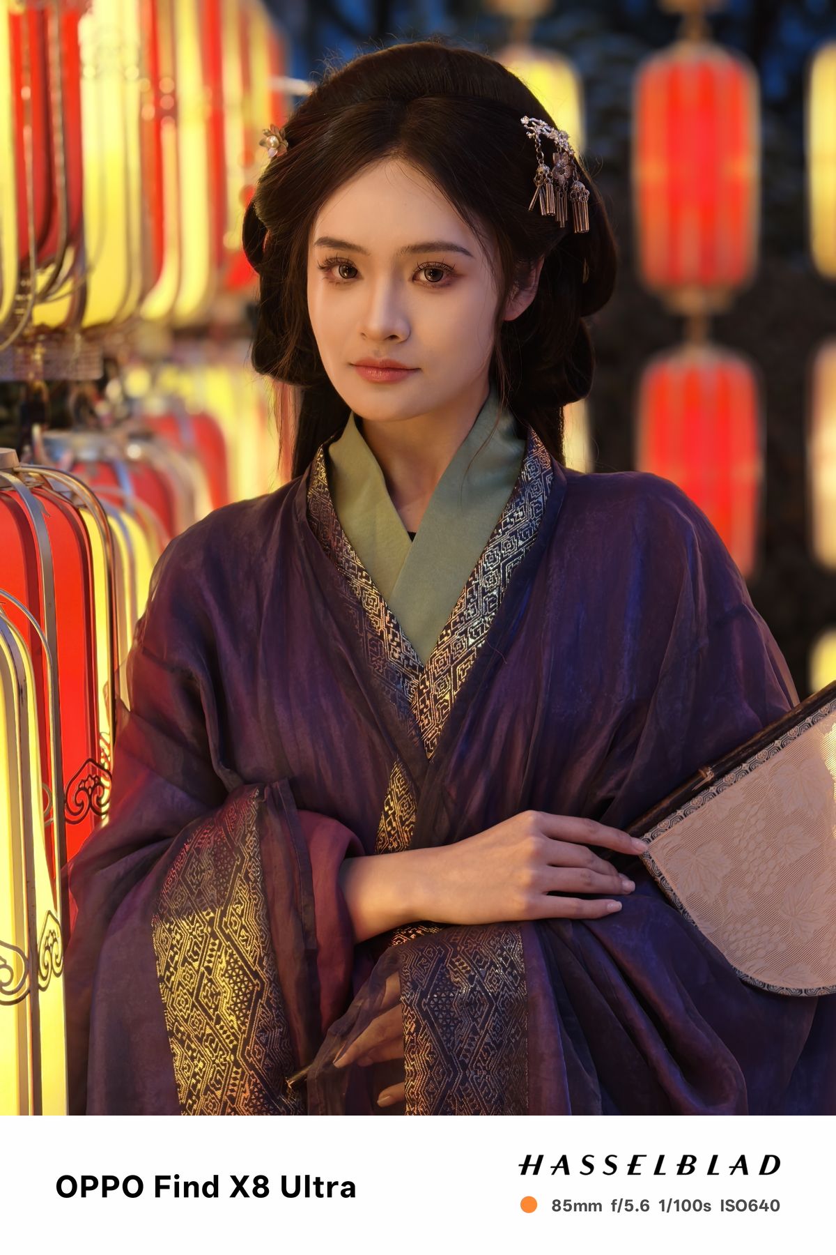 A person in traditional Chinese dress posing with a fan
