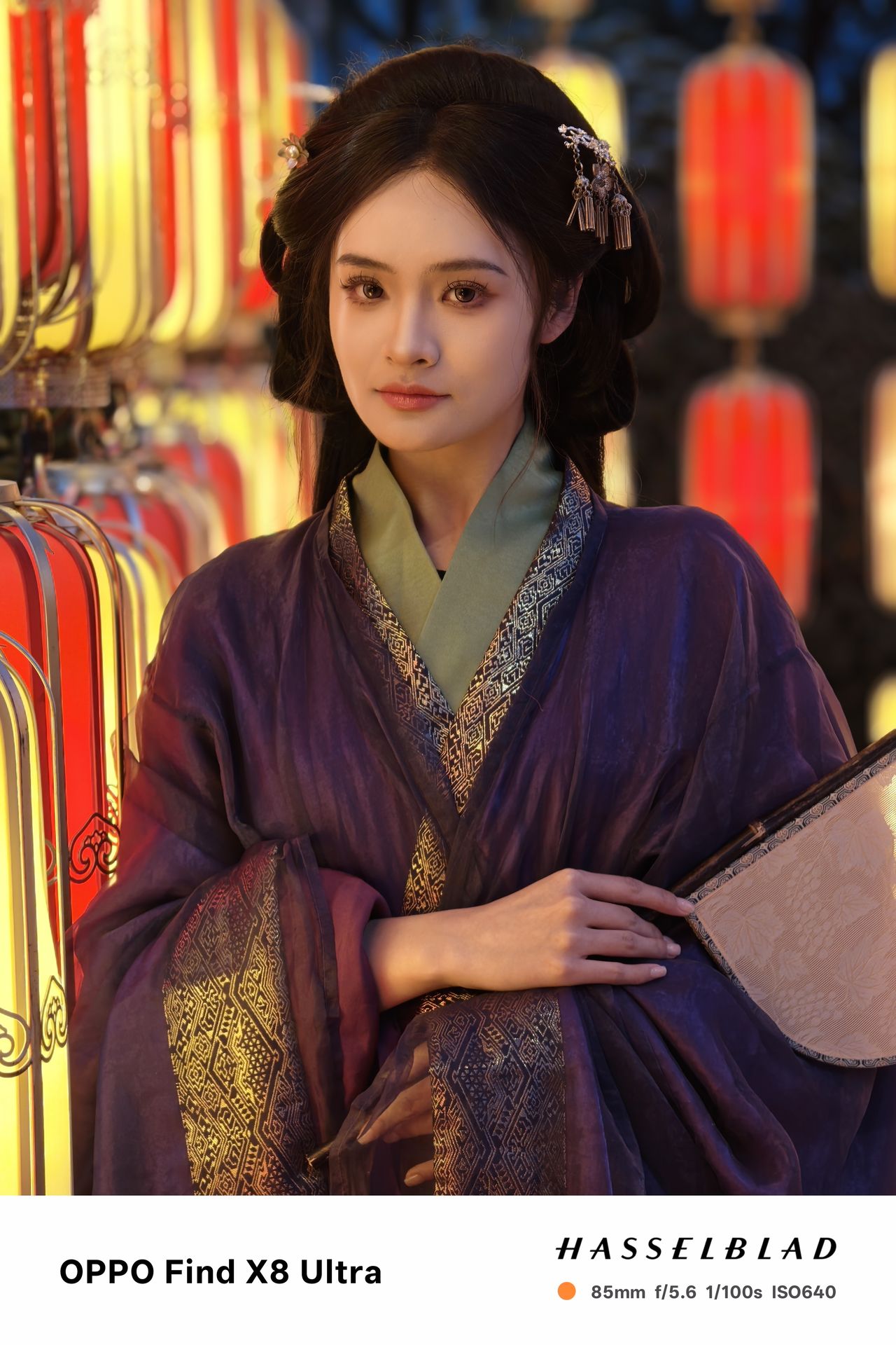 A person in traditional Chinese dress posing with a fan