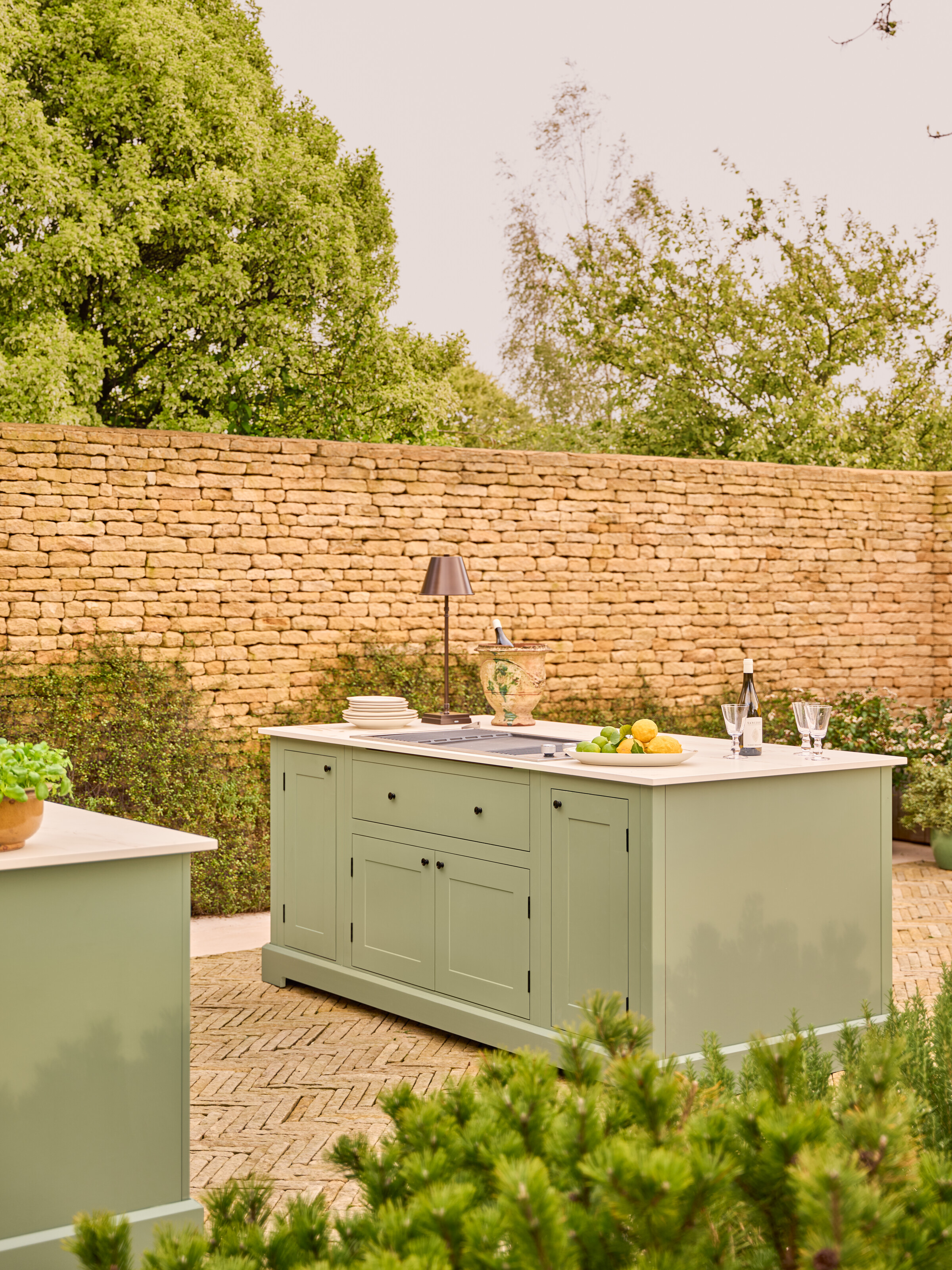 sage green outdoor kitchen with an island