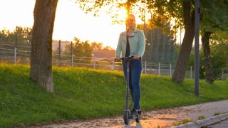 Woman scootering along path