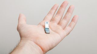 Photo of a tiny folding toy phone in the palm of a hand