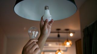 Energy saving light bulbs being put in a ceiling light 