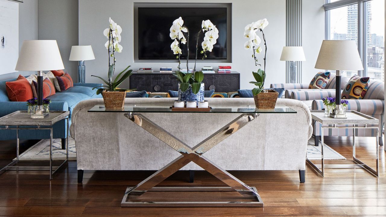 living room with blue sofa tv unit and wooden flooring