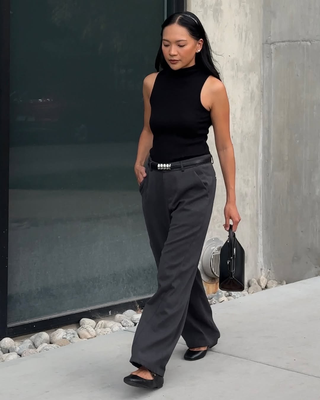Dawn in black high-neck top and grey trousers