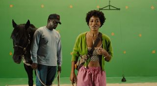 (L to R) A horse, Daniel Kaluuya as OJ and Keke Palmer as Emerald stand in front of a green screen in Jordan Peele's Nope