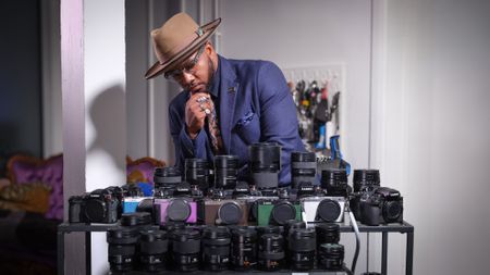 Jon Devo standing behind a display of Panasonic mirrorless cameras and lense
