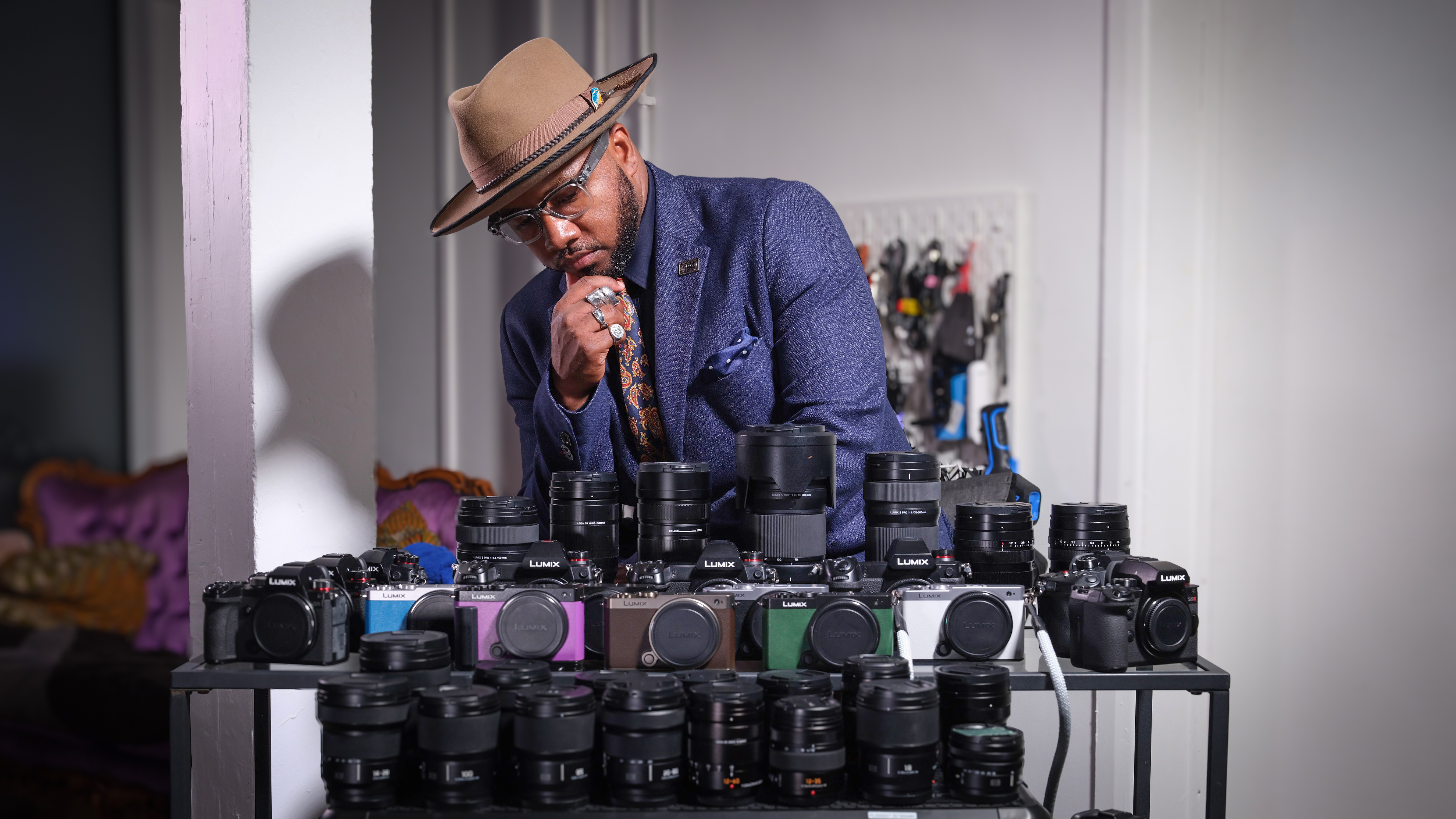 Jon Devo standing behind a display of Panasonic mirrorless cameras and lense
