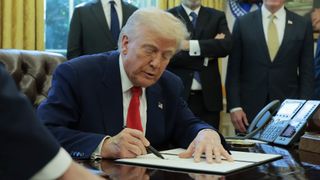 U.S. President Donald Trump signs a executive order.