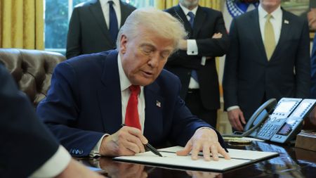 U.S. President Donald Trump signs a executive order.