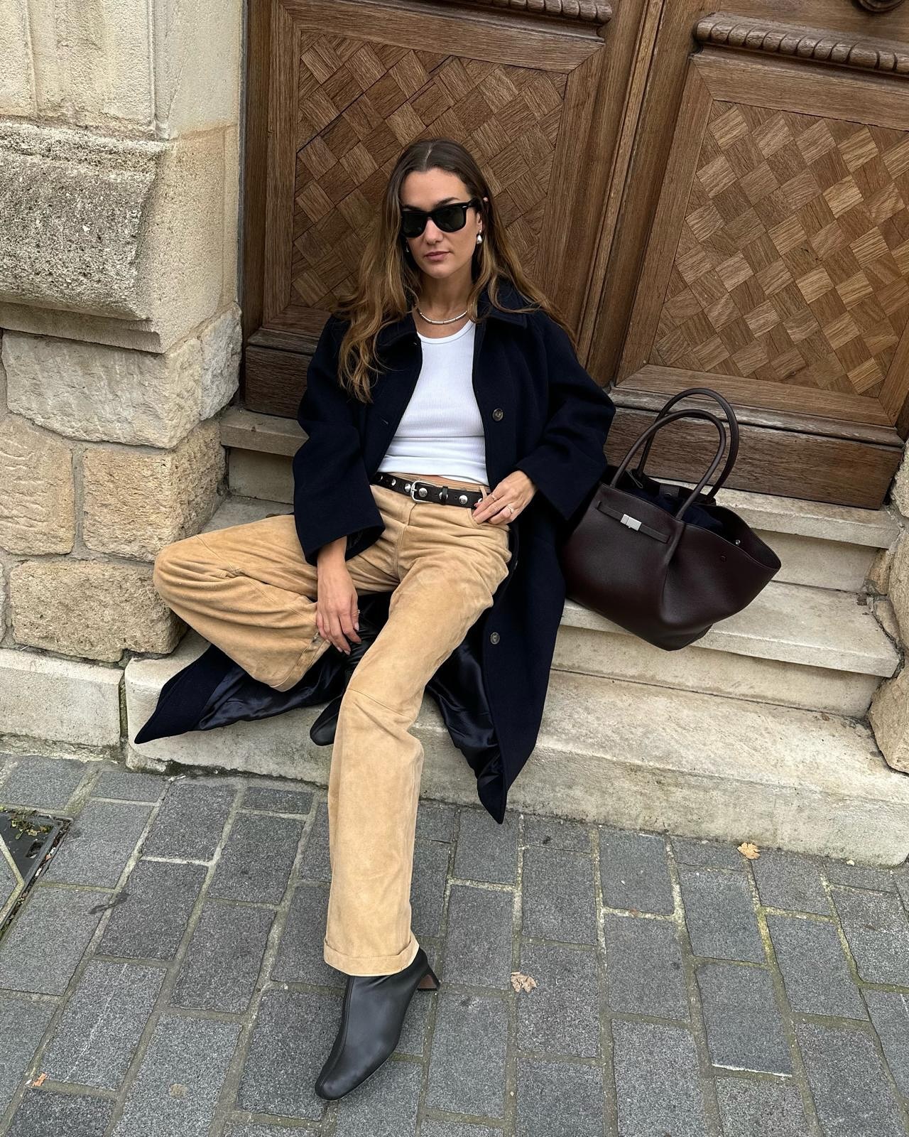 anne laure mais wears a long navy coat, white tshirt and khaki jeans with boots