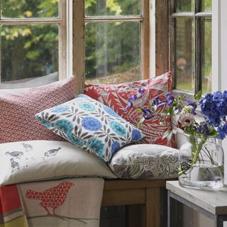 window seating area with cushion and vase with flower