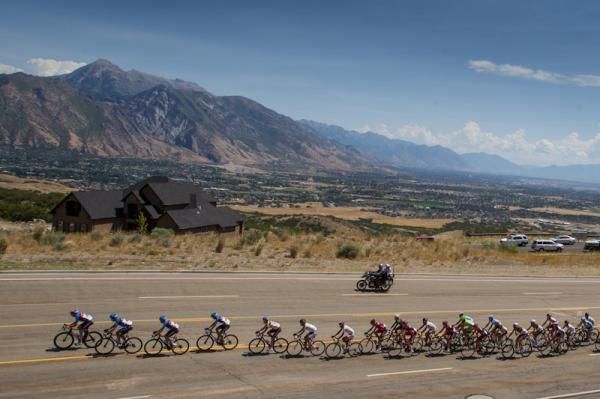 The peloton heads away from the mountains before turning back into them