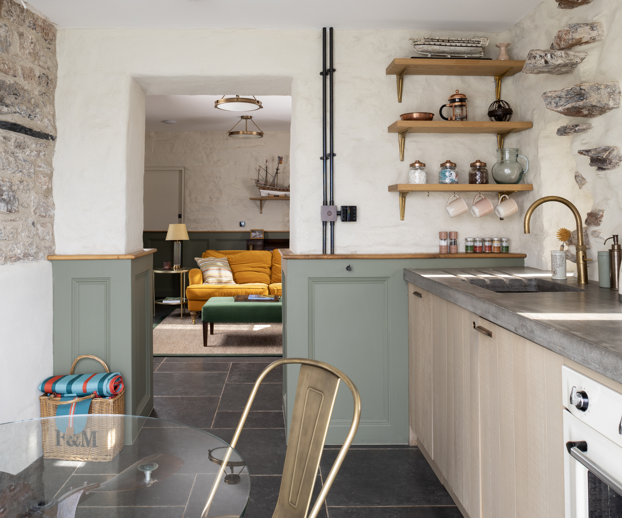 Kitchen with stone walls and an open entryway that leads into the living room