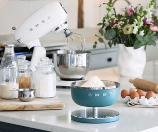 Smeg digital scale on countertop. There is a stand mixer in the background with ingredients placed around it.