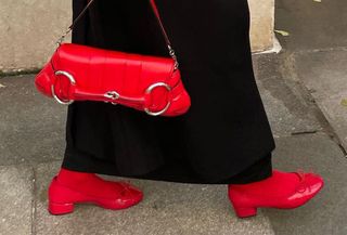 Woman wears black coat, red Gucci horsebit bag and red Steve Madden Cherish pumps.