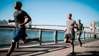 Three runners on the Brooklyn waterfront with Brooklyn Bridge in the background 