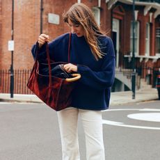 Woman in J.Crew navy sweater and white corduroy pants