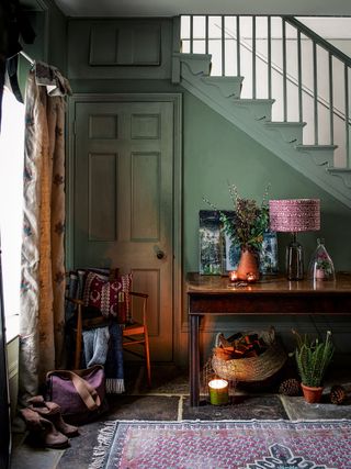 Cozy green entryway with console table and lamp
