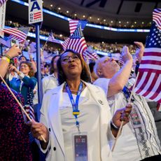 Delegates wearing white wave US flags during the Democratic National Convention (DNC) at the United Center in Chicago, Illinois, US, on Thursday, Aug. 22, 2024. 