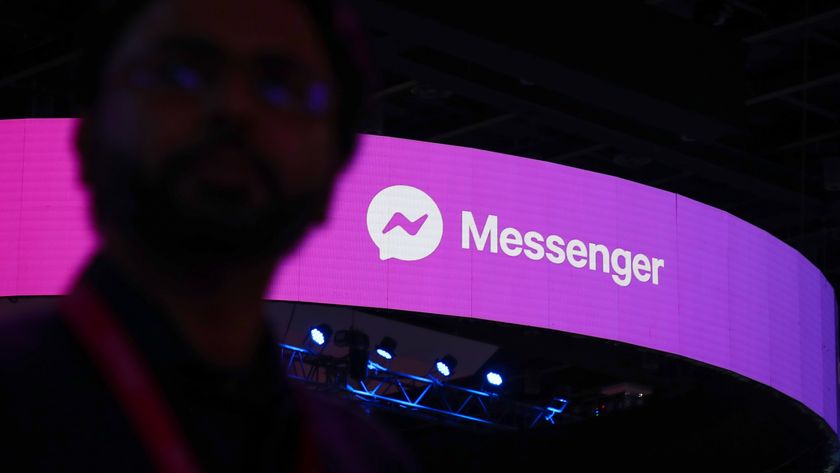 A man walks past a logo of Facebook messenger