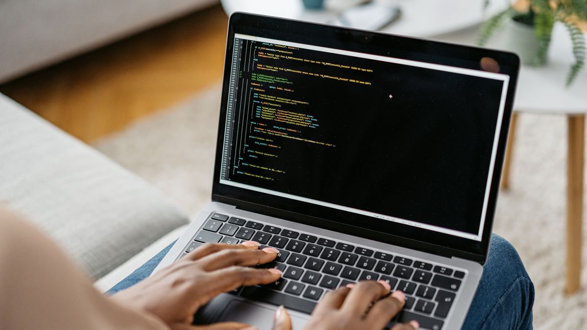 Somebody typing code into a UI in a laptop