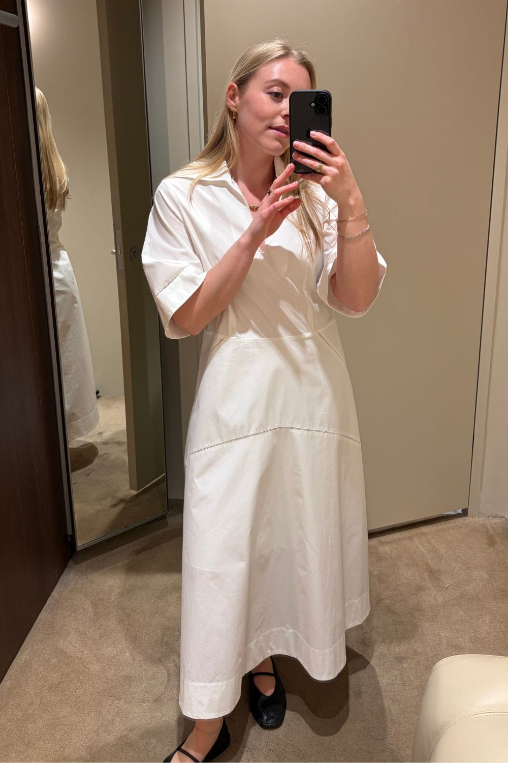 Woman wears white COS dress and black ballet flats