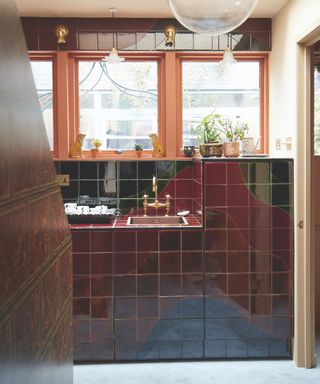 bathroom with dark red and green tile surround