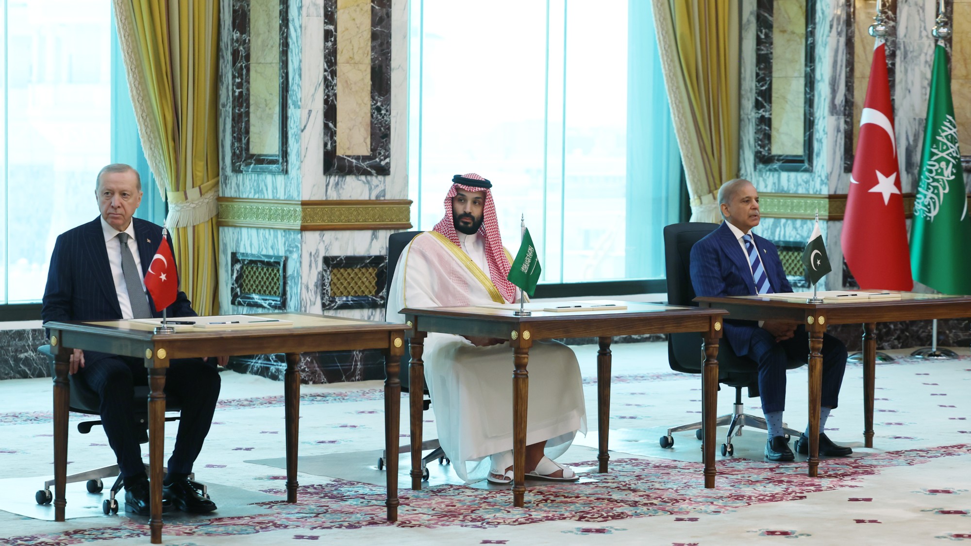 Turkish President Recep Tayyip Erdogan (L), Saudi Crown Prince Mohammed bin Salman (C), and Pakistani Prime Minister Shehbaz Sharif (R) sign a trilateral defense agreement in Mecca, Saudi Arabia