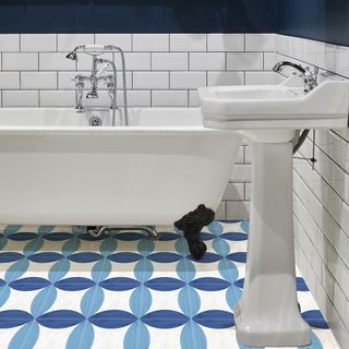 bathroom with crisp white metro tiles and bold pattern on the floor