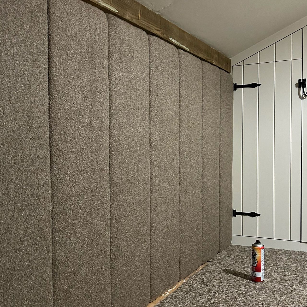 Upholstered panelled headboard on wall of country eaves bedroom before bed is added