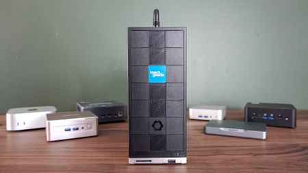 A number of different mini PCs on a desk with the Framework Desktop front and center