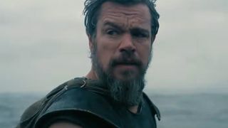 Matt Damon looking back at his men wearing full armour as the ocean looms.