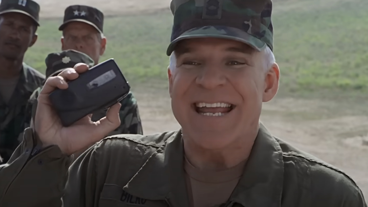 Steve Martin enthusiastically holding a tape recorder in military fatigues in Sgt. Bilko