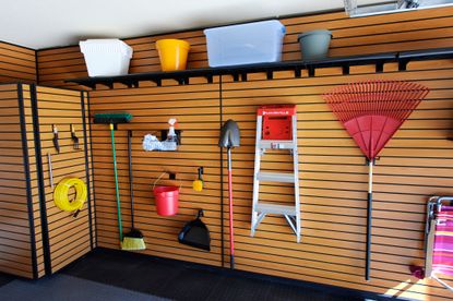 An organised garage with tools hung on the wall