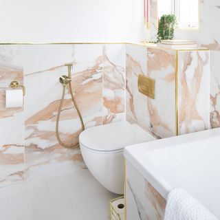 marble and white bathroom with wall hung toilet and basin