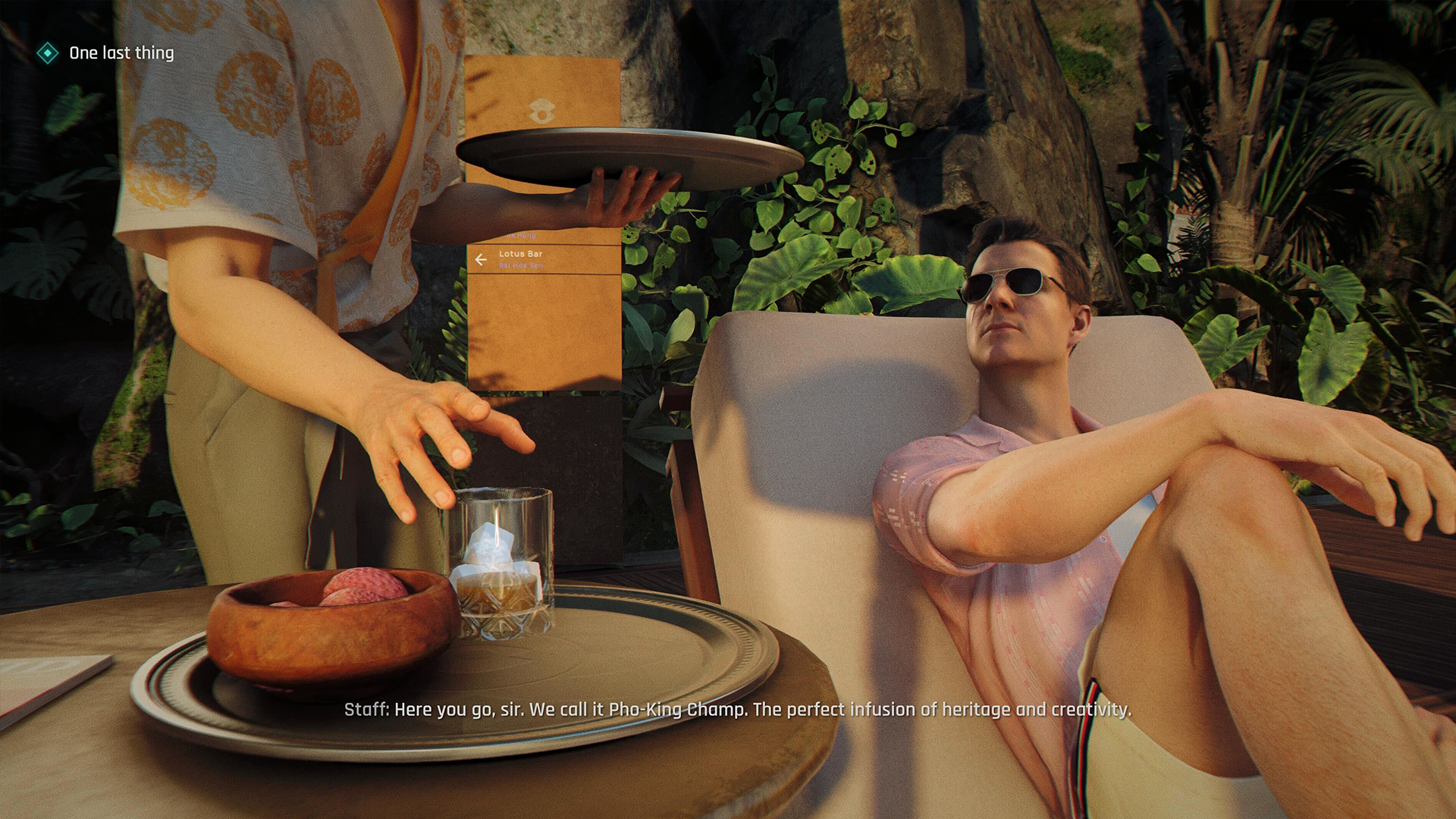 A screengrab from 007 First Light of James Bond being served a drink in a resort while sitting on a lounge chair