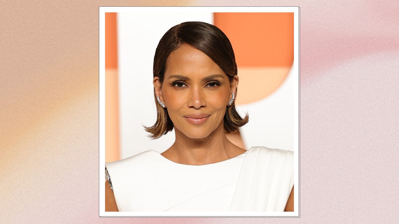 Image of Halle Berry with brunette bell-bottom bob, smiling and wearing a white gown, on a pink watercolour background