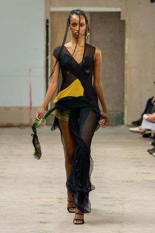 Model on runway wears sheer dress by Jawara Alleyne at London Fashion Week S/S 2023