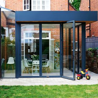 Exterior of brick home with modern black steel conservatory