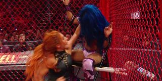Becky Lynch placing Sasha Banks on a chair at Hell in a Cell 2019