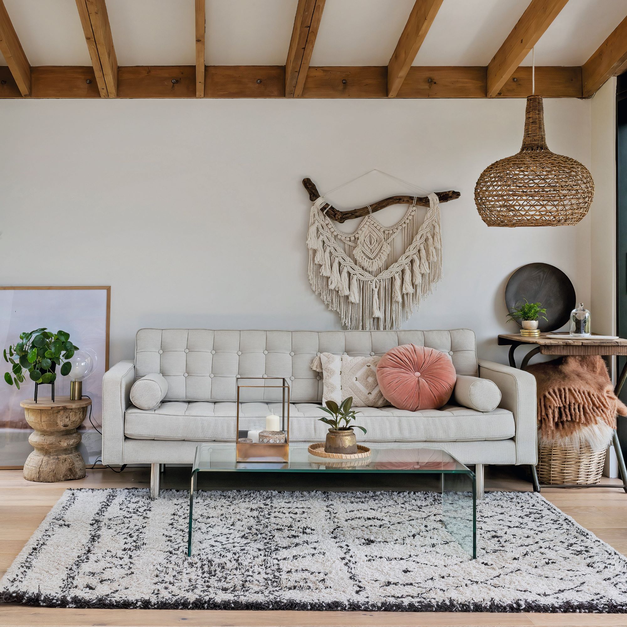 sofa with cushions and glass dining table on rug