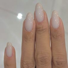 Close up picture of long almond nails with a sheer milky nail colour