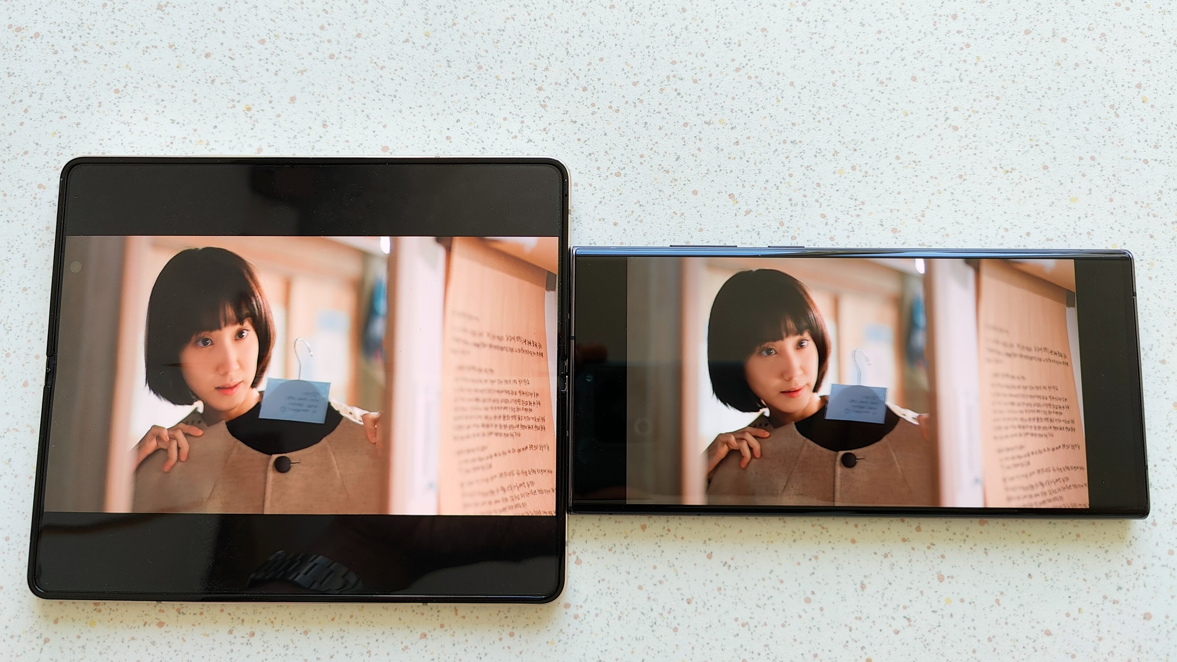 Samsung Galaxy Z Fold 4 ligger ved siden af Galaxy S22 Ultra - begge viser samme klip fra Netflix.