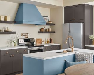 modern kitchen with dark gray cabinets, blue island unit and blue extractor fan