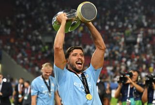 Ruben Dias of Manchester City celebrates with the UEFA Super Cup trophy after the team's victory in the UEFA Super Cup 2023 match between Manchester City FC and Sevilla FC at Karaiskakis Stadium on August 16, 2023 in Piraeus, Greece.