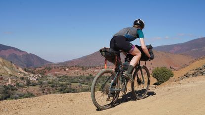 Anna riding on a gravel trail over the Atlas Mountains in Morocco