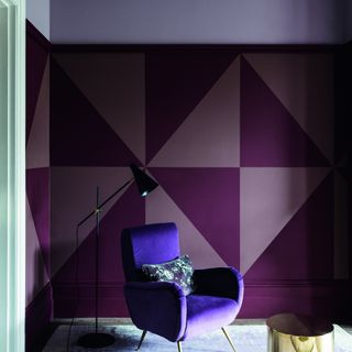 A living room with the walls and ceiling painted in a graphic pattern using various shades of purple