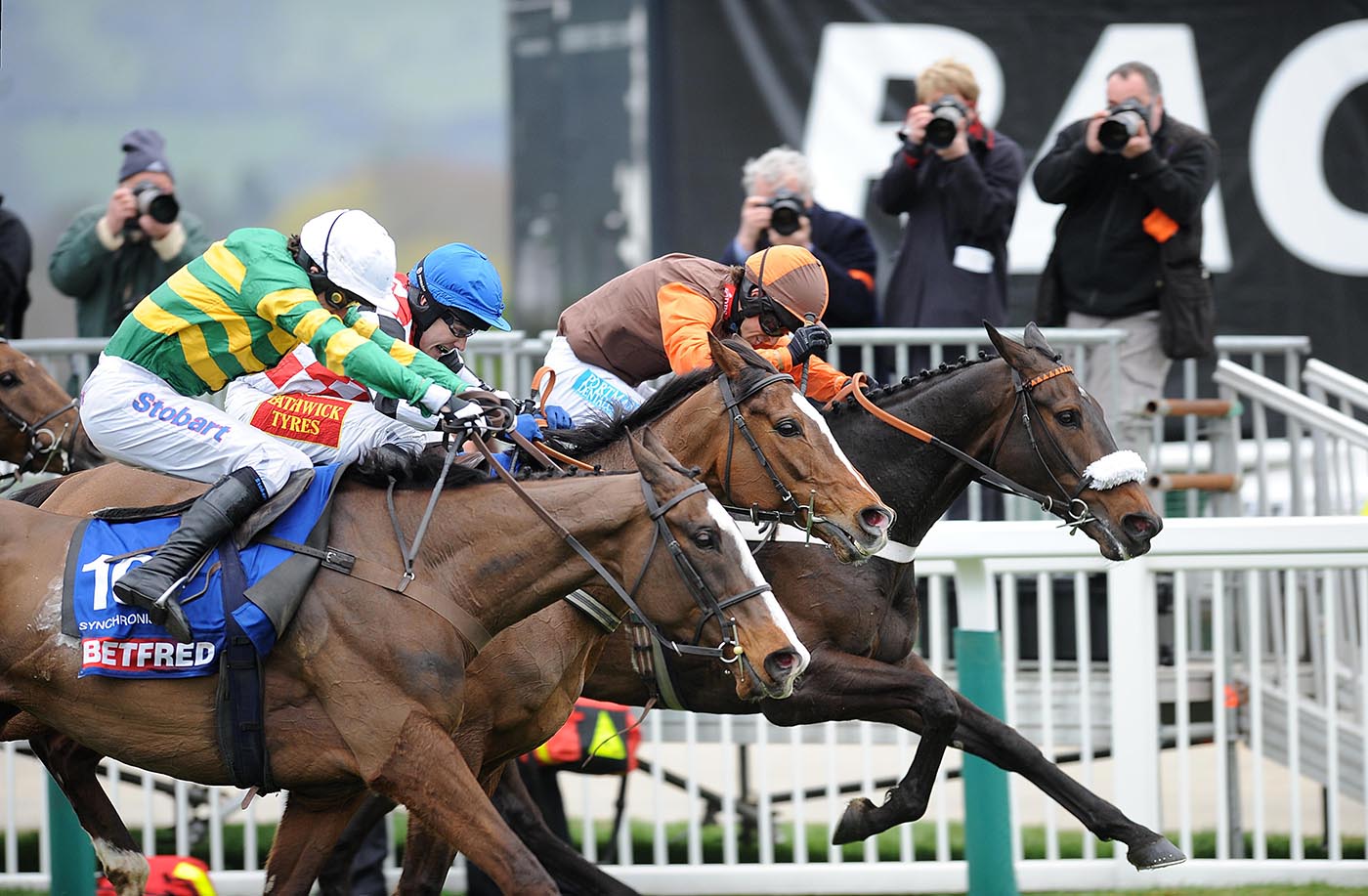 G51RJ6 Synchronised ridden by jockey Tony McCoy (left) on his way to winning the Betfred Cheltenham Gold Cup ahead of Long Run ridden by Sam Waley-Cohen (right), on Gold Cup Day, during the Cheltenham Festival.
