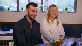 Nick Dorka and Hannah Jiles sit in a restaurant, in 'Love is Blind' season 7.